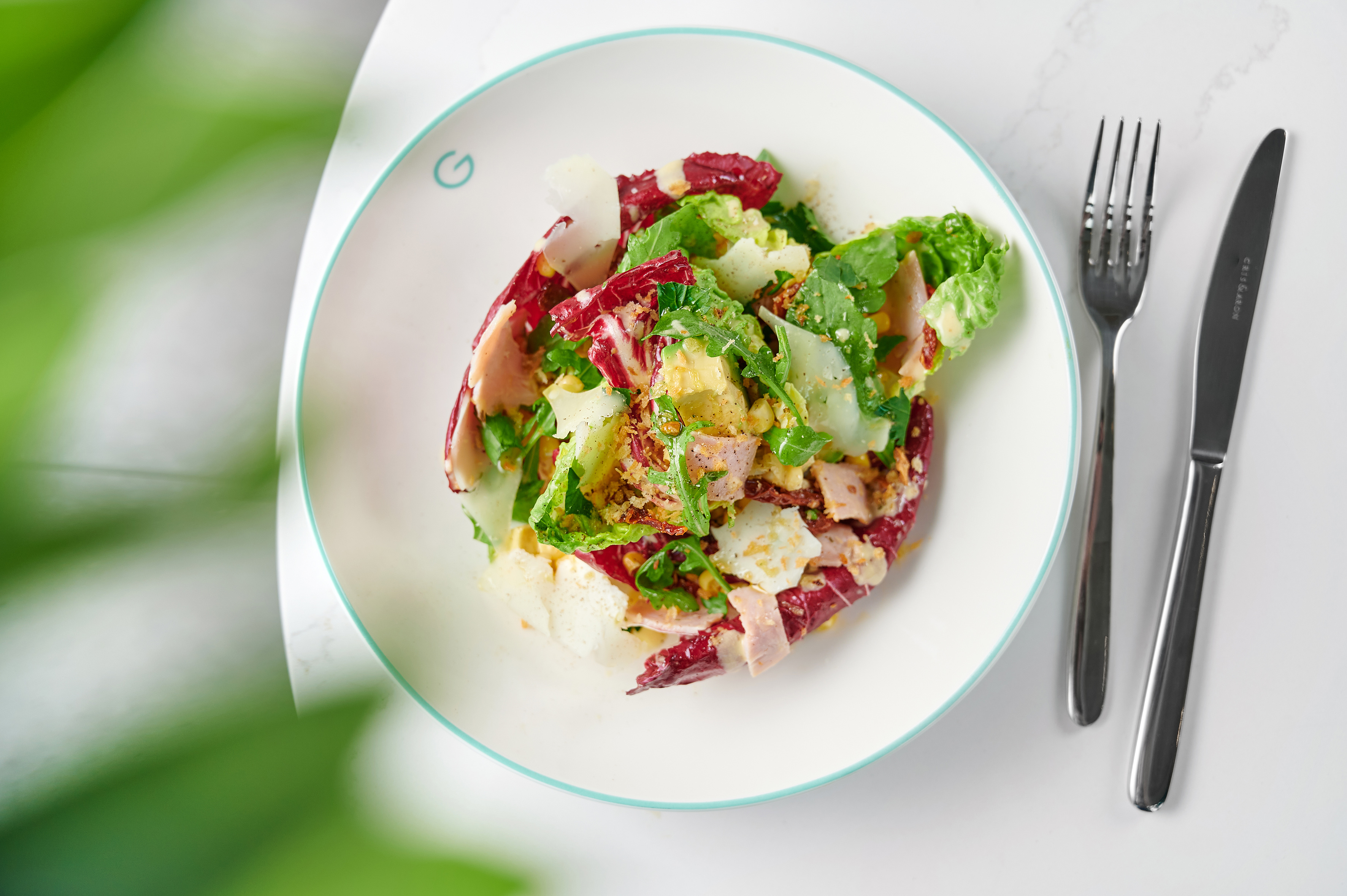 Fresh colorful salad with radicchio, greens, ham, cheese, and corn.