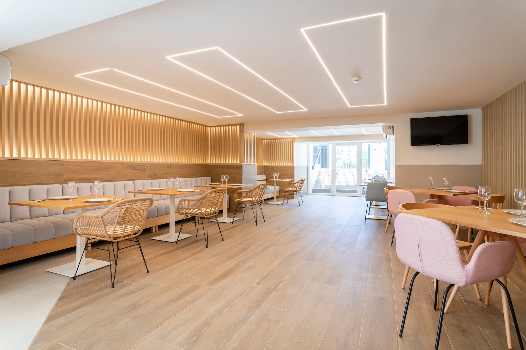 Modern restaurant dining, wood walls, banquettes, and linear ceiling lights.