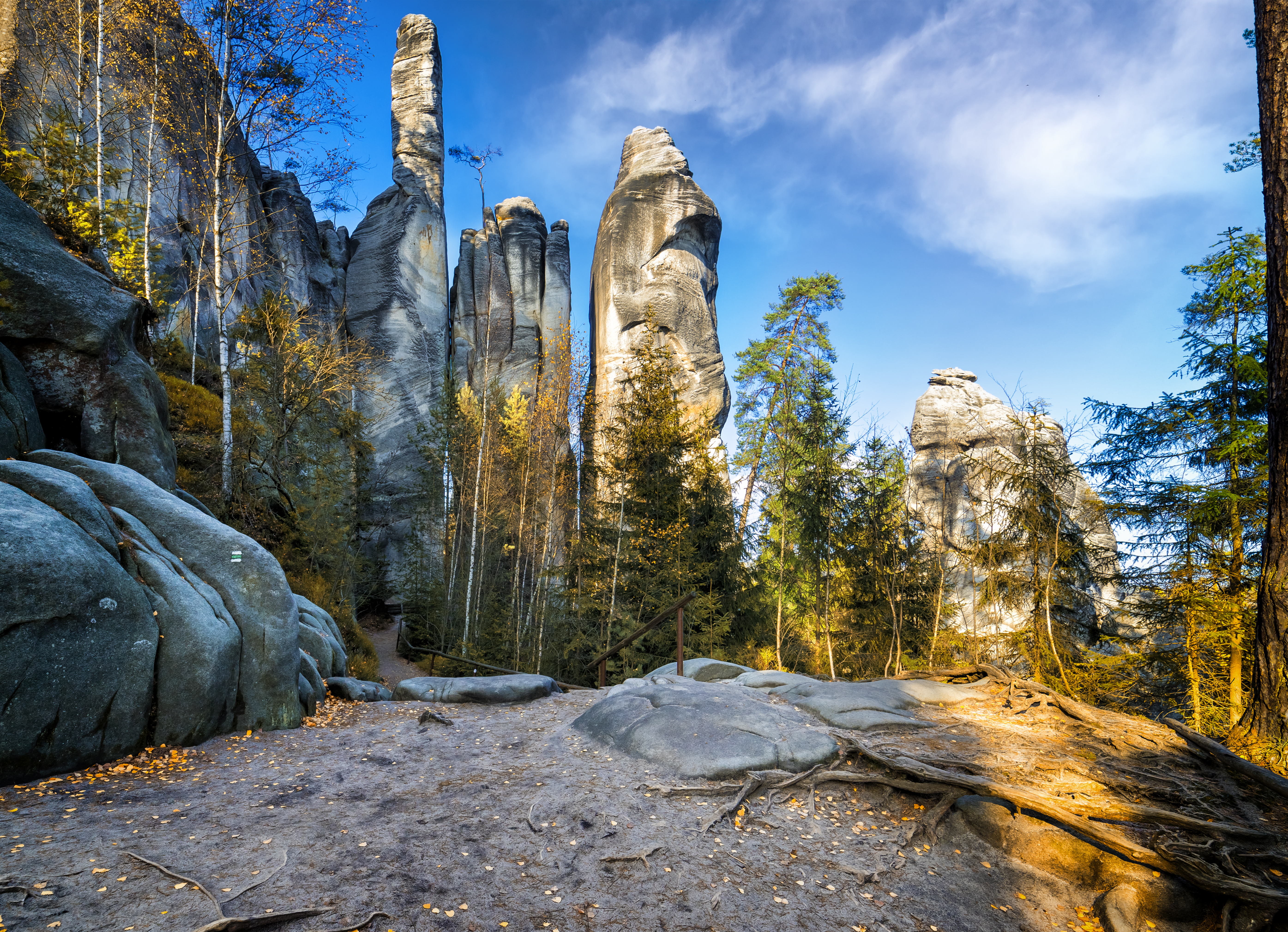 a rocky landscape with trees and a blue sky