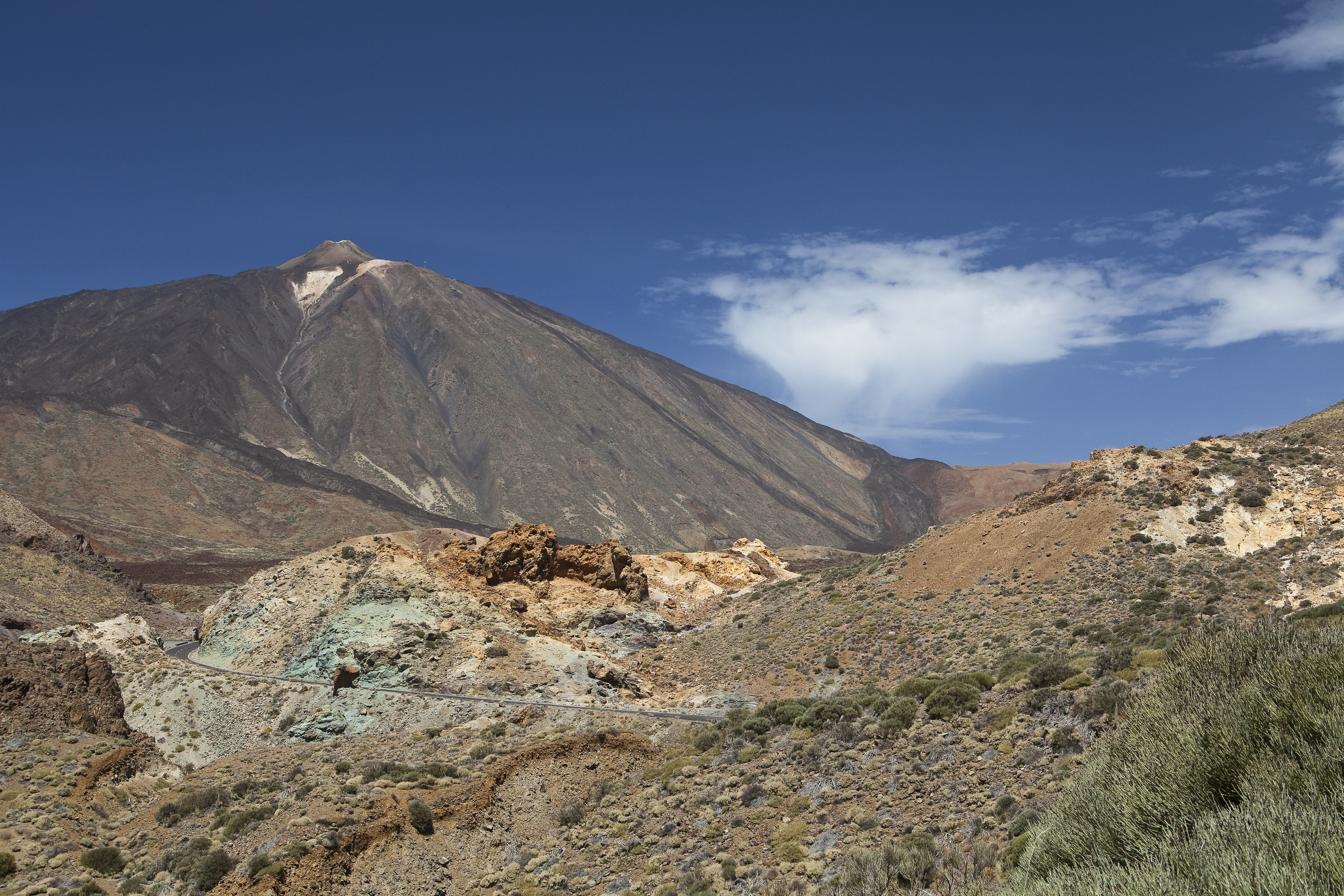 Teide volcano, Tenerife, with rocky volcanic landscape and winding mountain road.