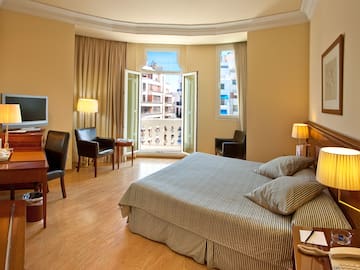 a bedroom with a bed and a table and chairs