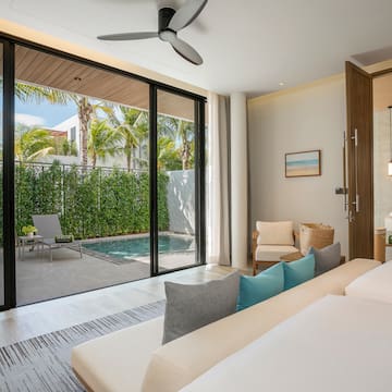 a room with a bed and a pool in the background