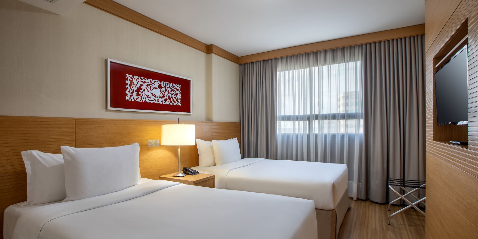 a room with two beds and a lamp