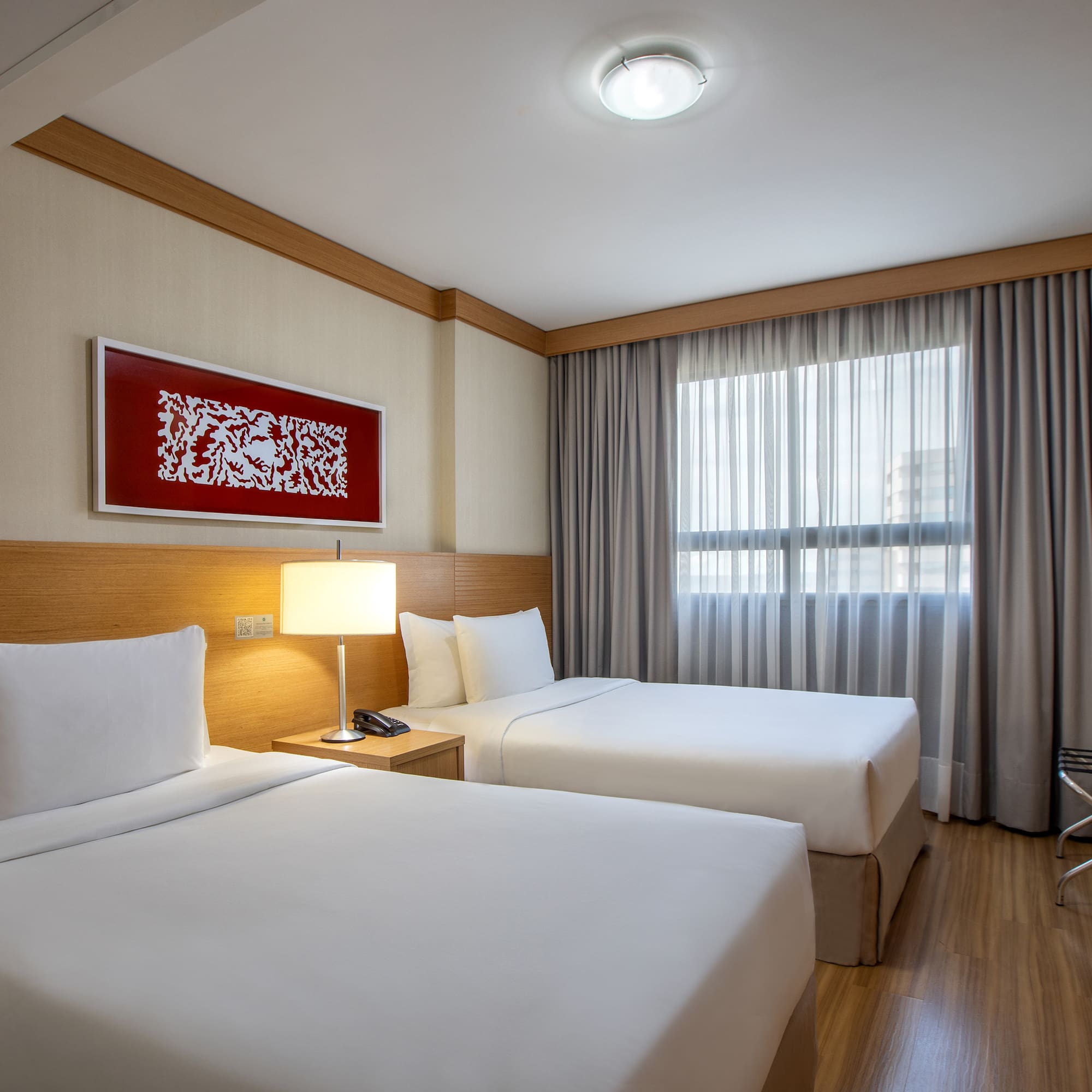 a room with two beds and a lamp