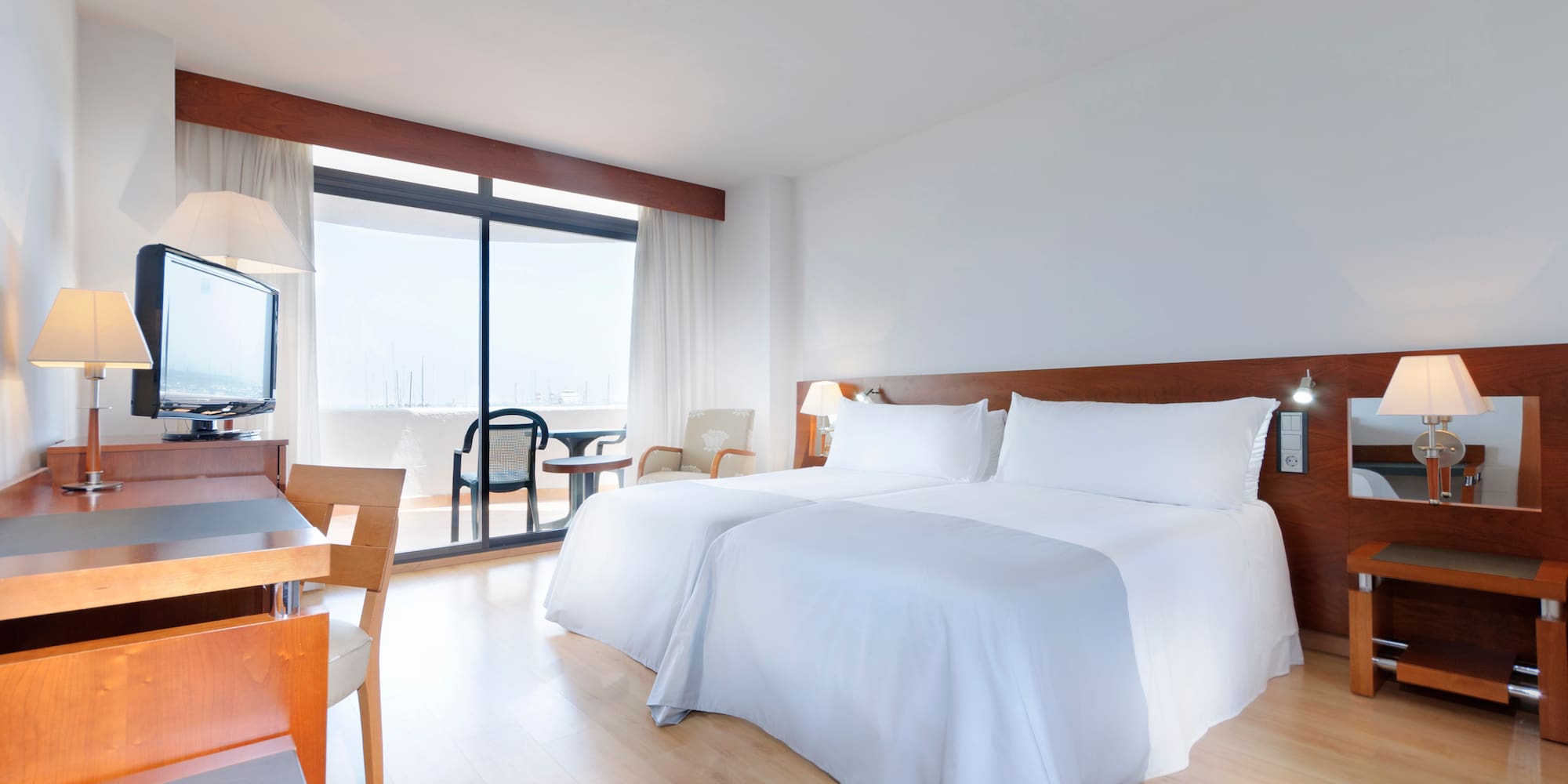 a room with two beds and a table and chairs