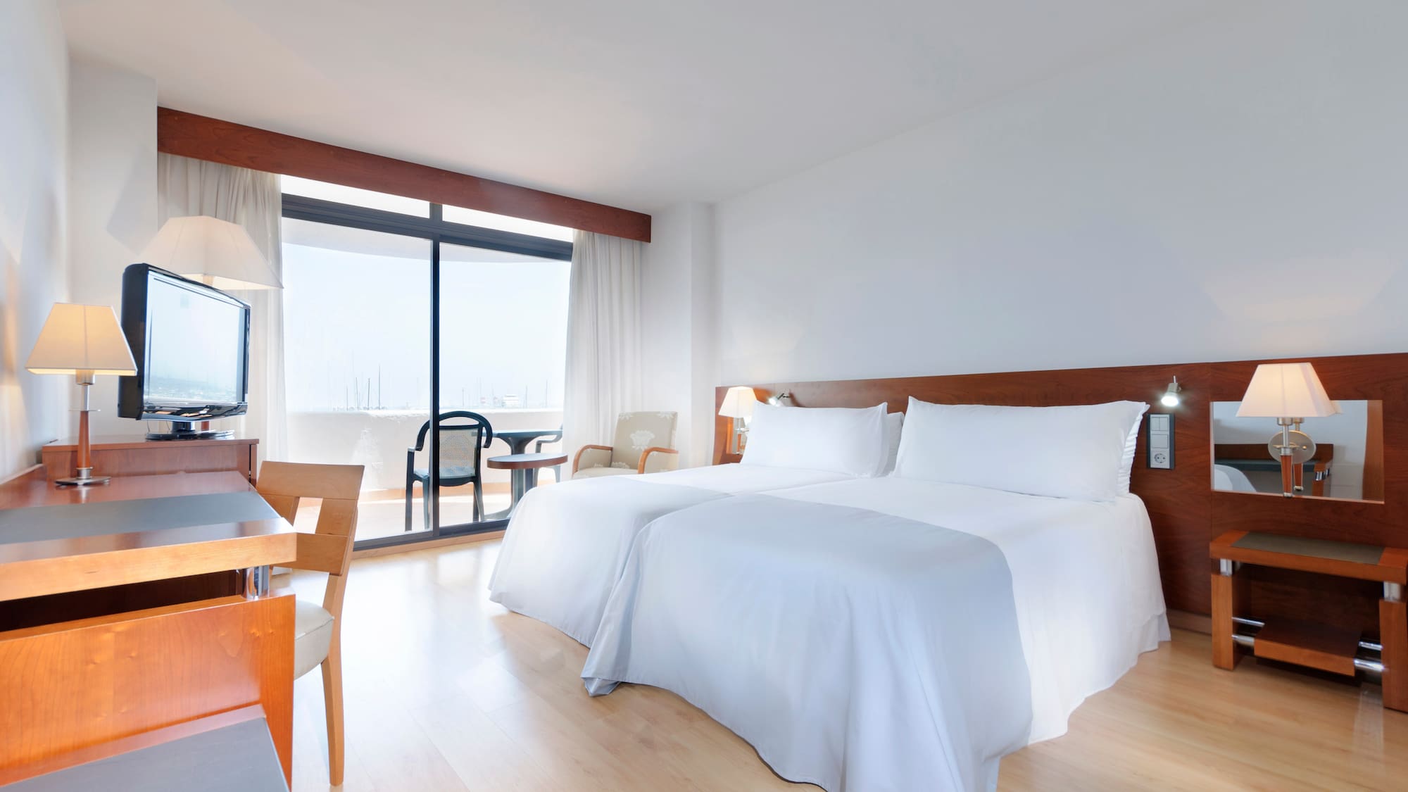 a room with two beds and a table and chairs