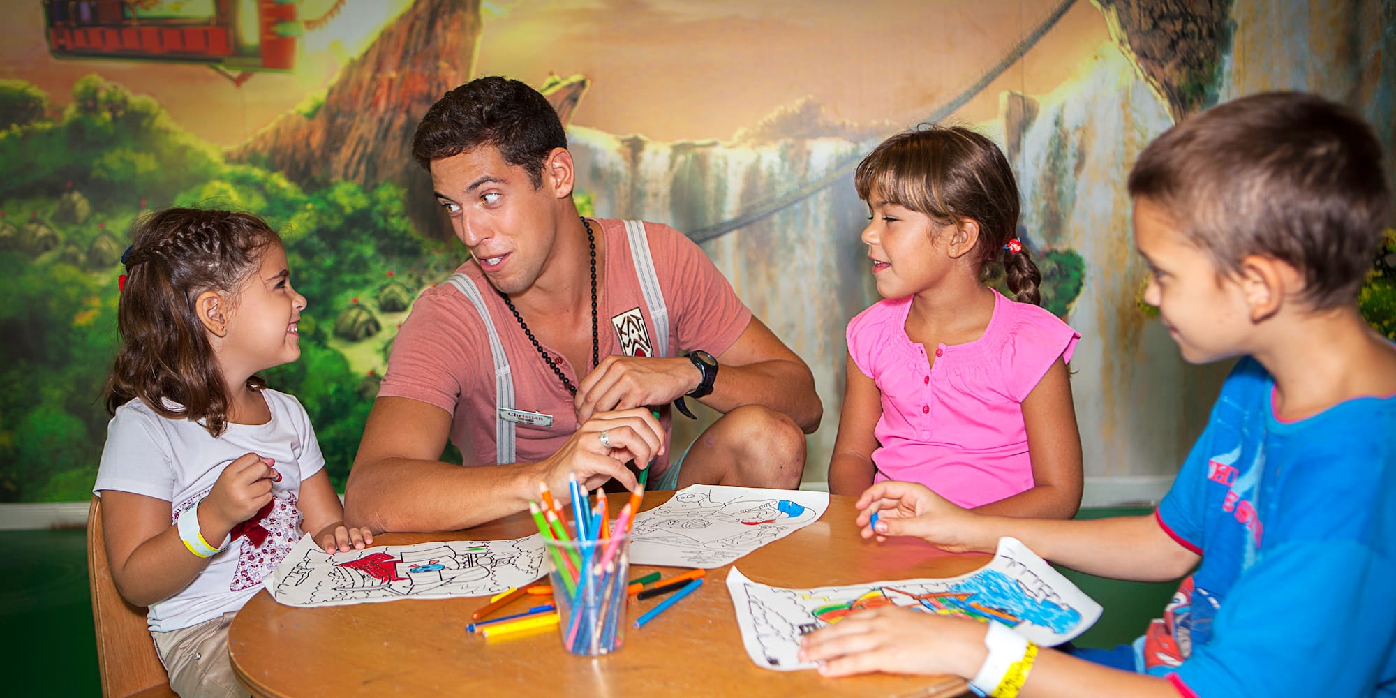 a man sitting at a table with children