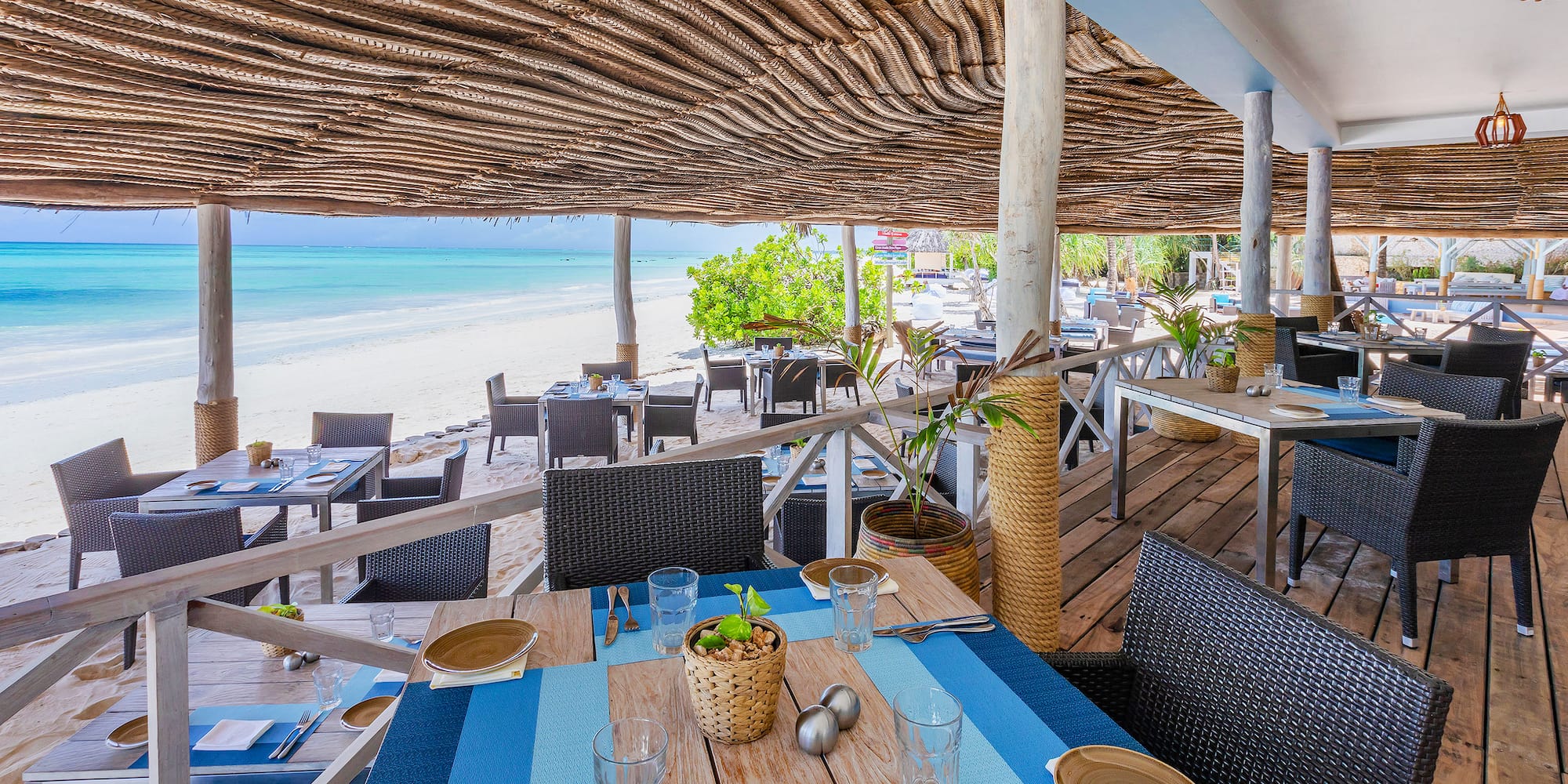 a restaurant with tables and chairs on a beach