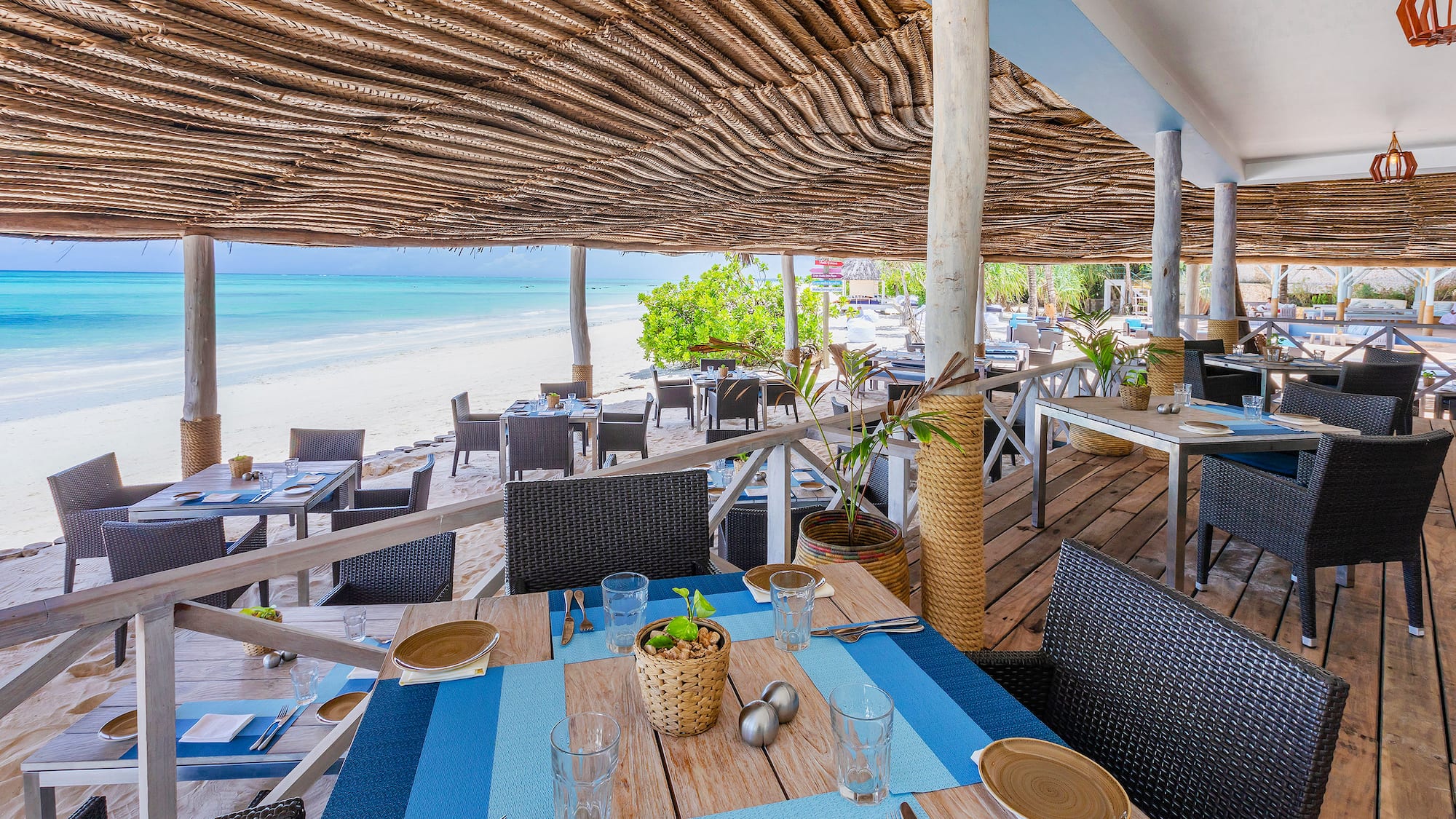 a restaurant with tables and chairs on a beach