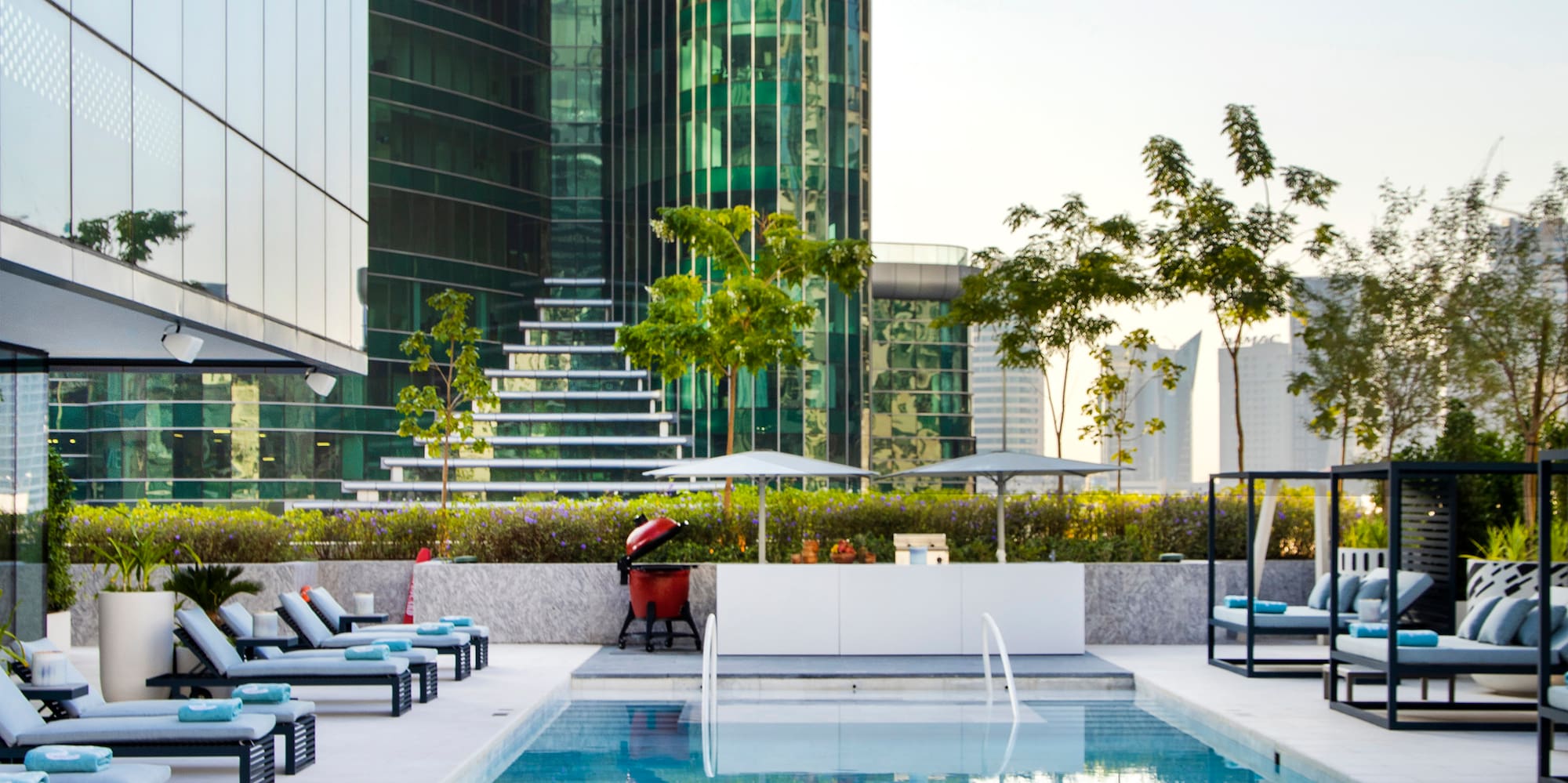 a pool with chairs and a large building in the background