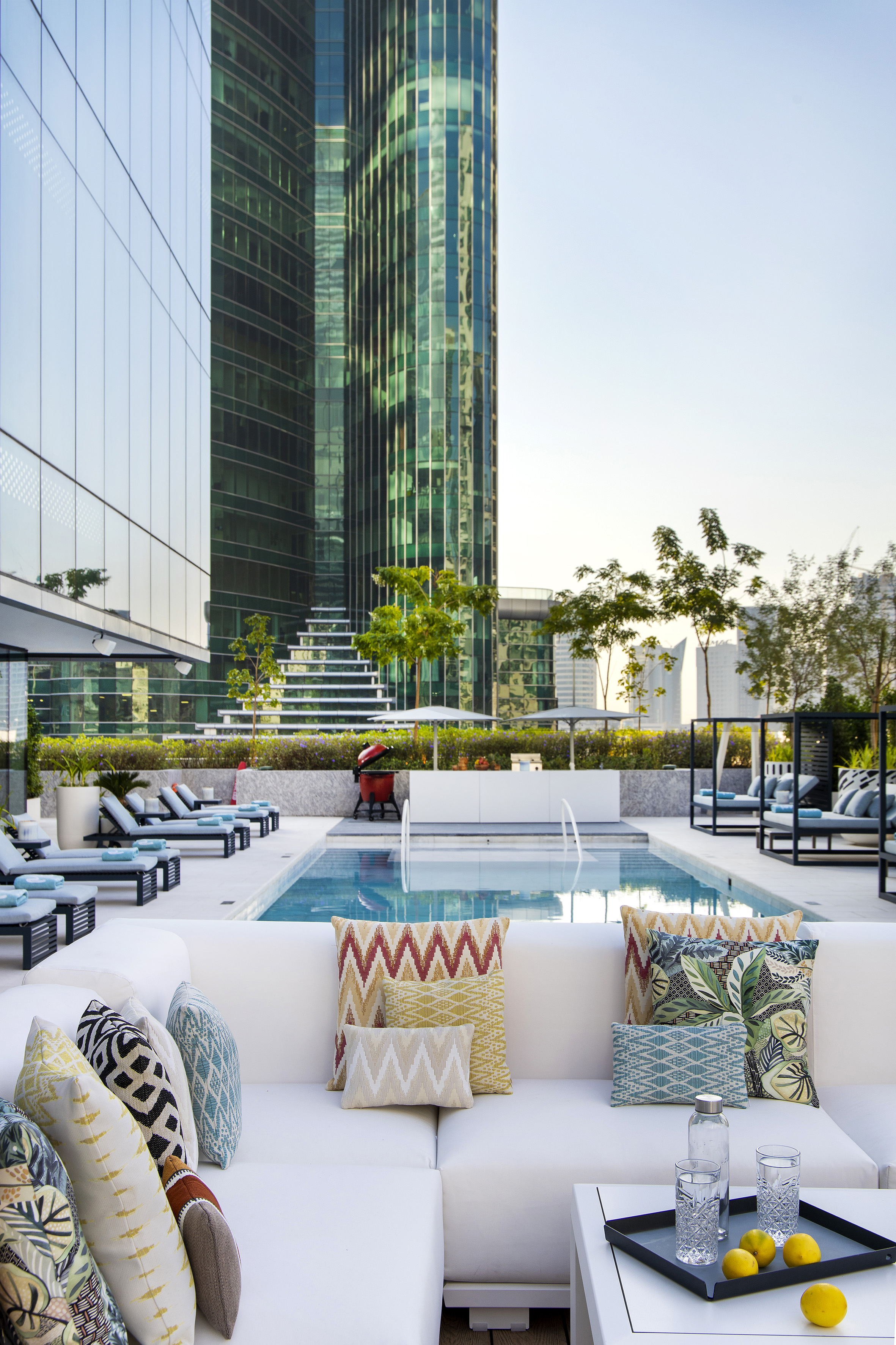a pool with chairs and a large building in the background