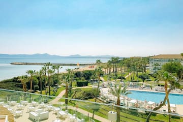 a pool and palm trees by a beach