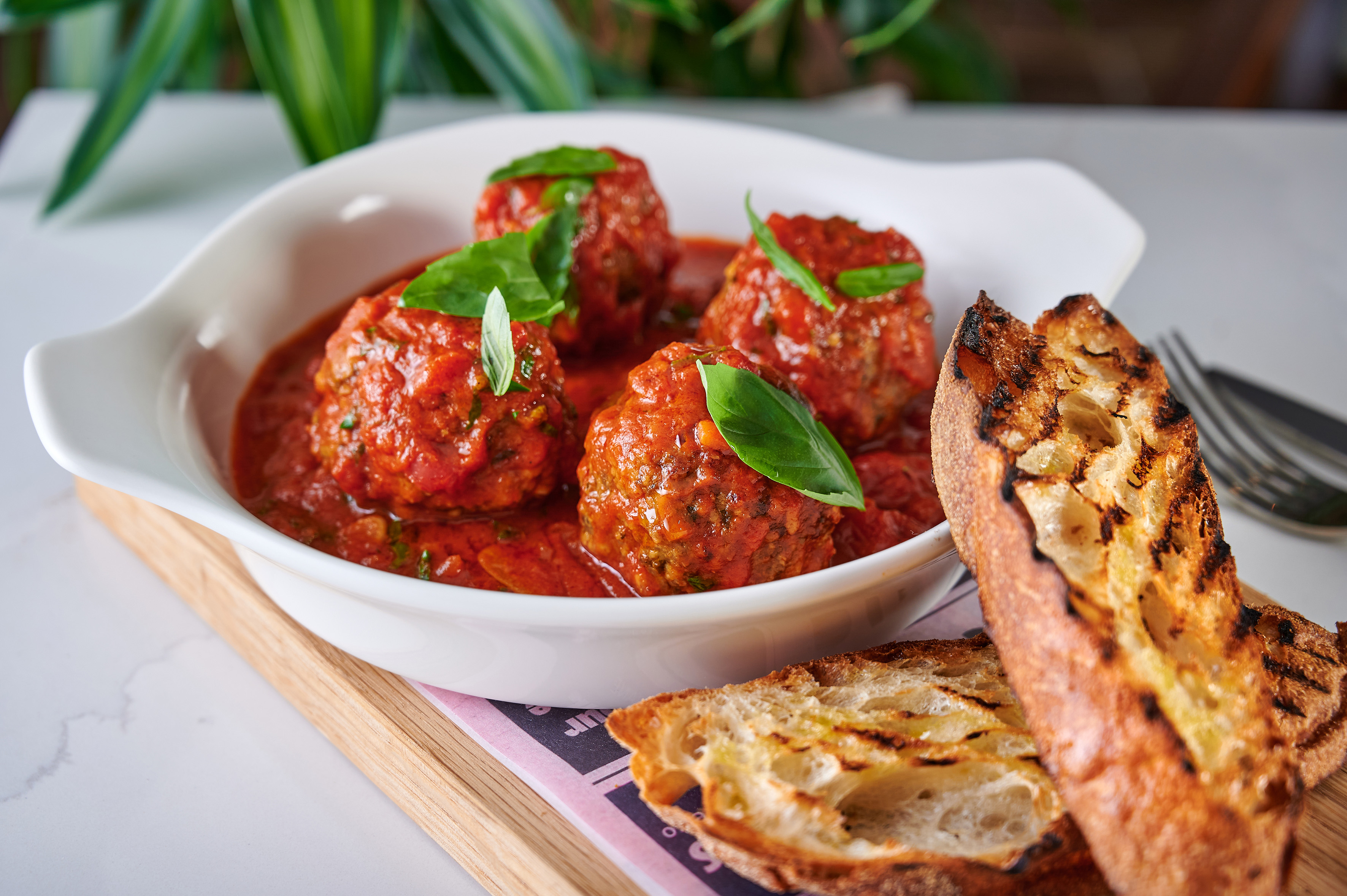 Italian meatballs with rich tomato sauce, fresh basil, and crusty grilled bread.