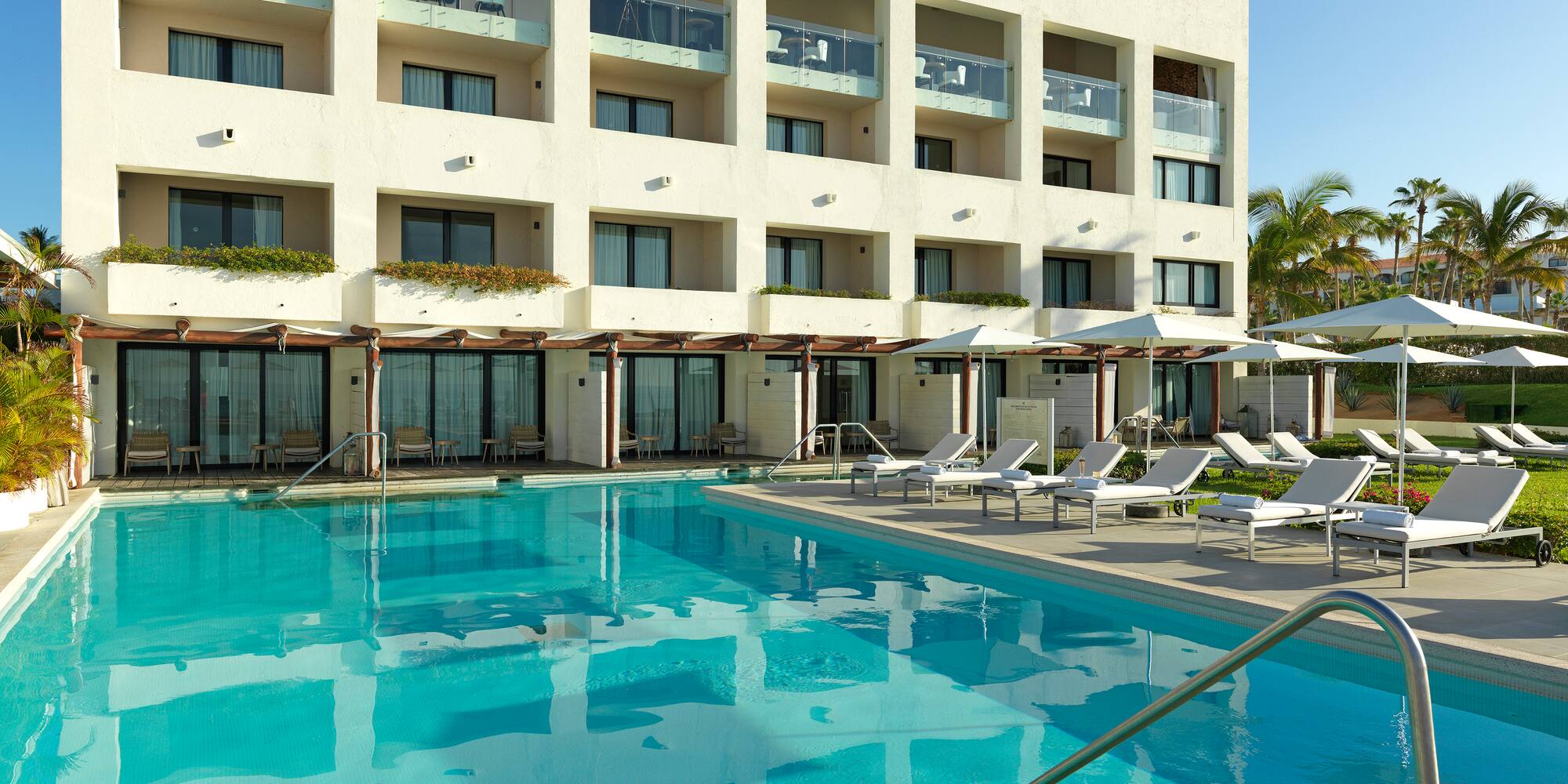 a pool with lounge chairs and a building