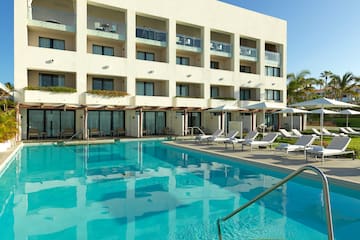a pool with lounge chairs and a building