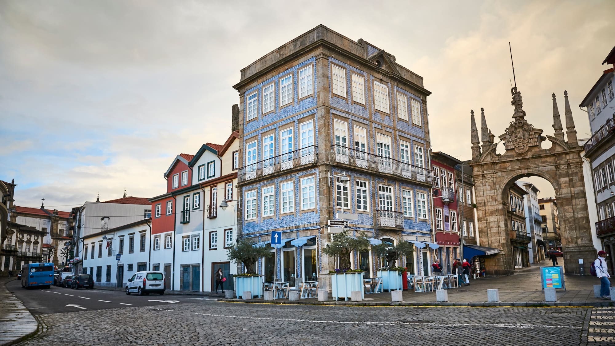 a street with buildings and a stone arch