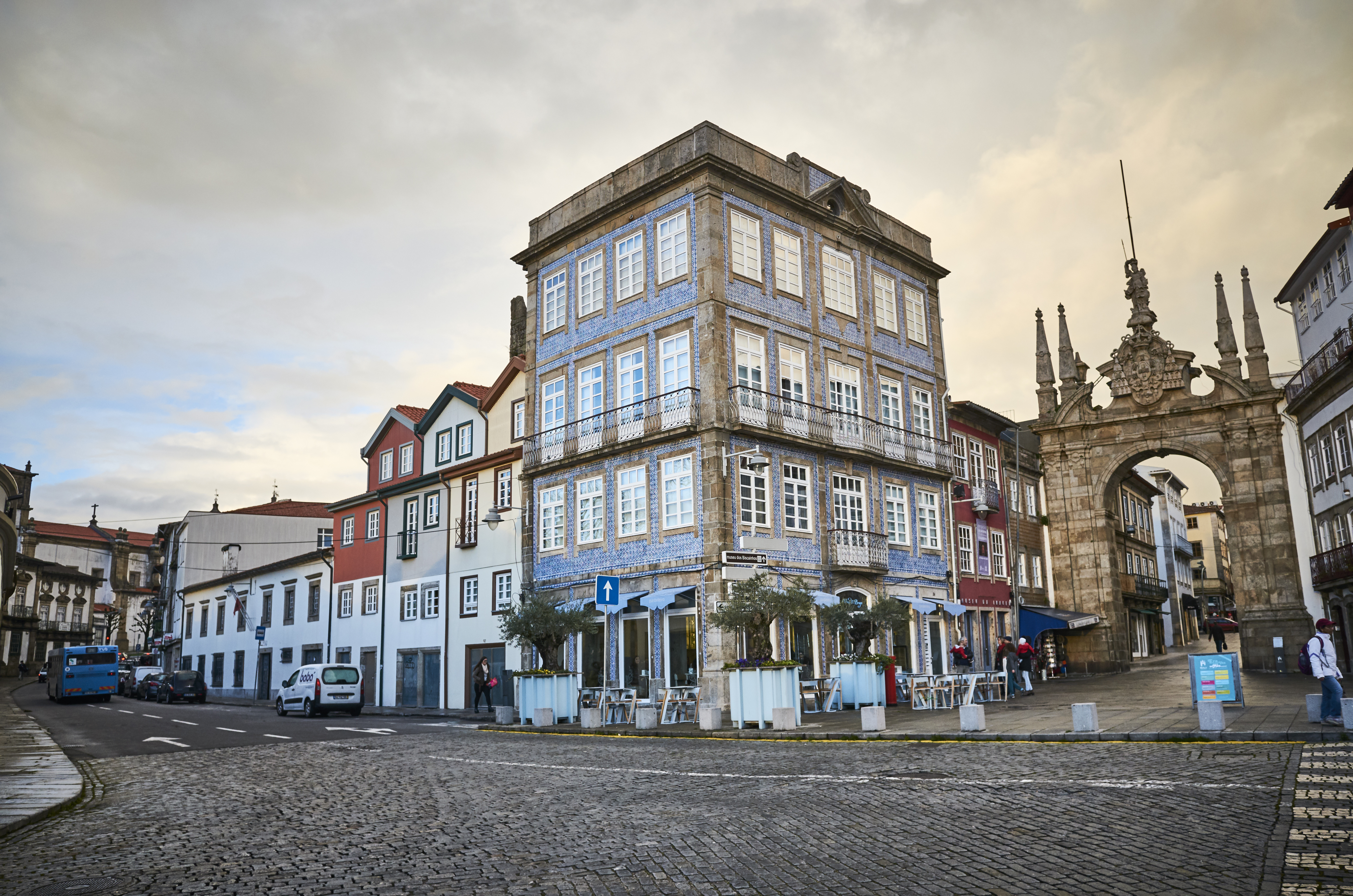 a street with buildings and a stone arch