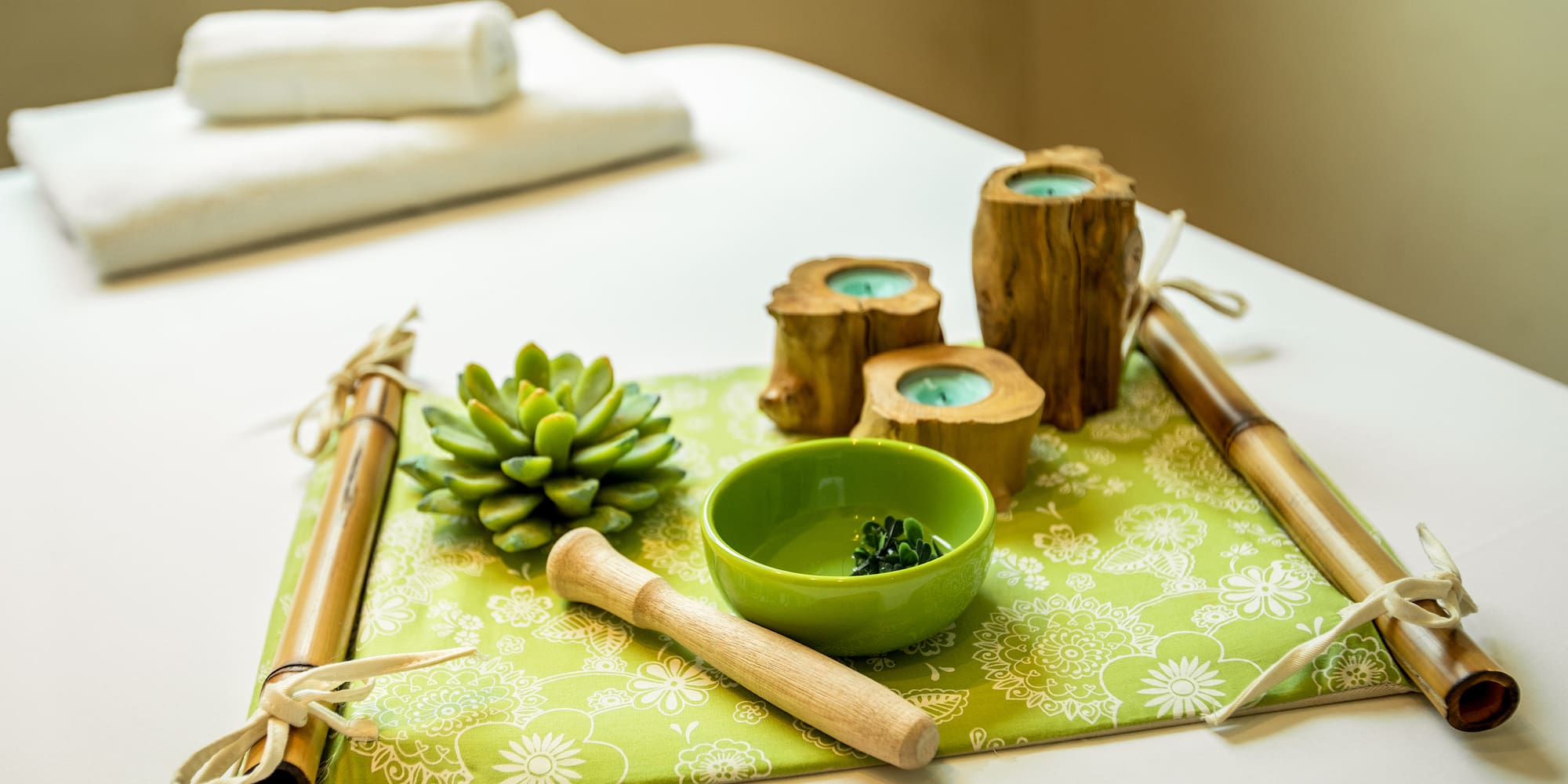 a green tray with candles and a bowl on it