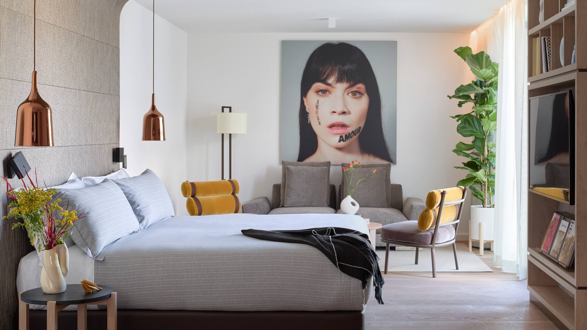 a bedroom with a bed and a chair and a plant