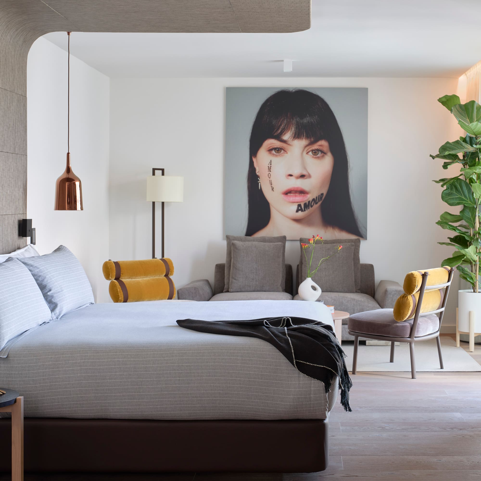 a bedroom with a bed and a chair and a plant