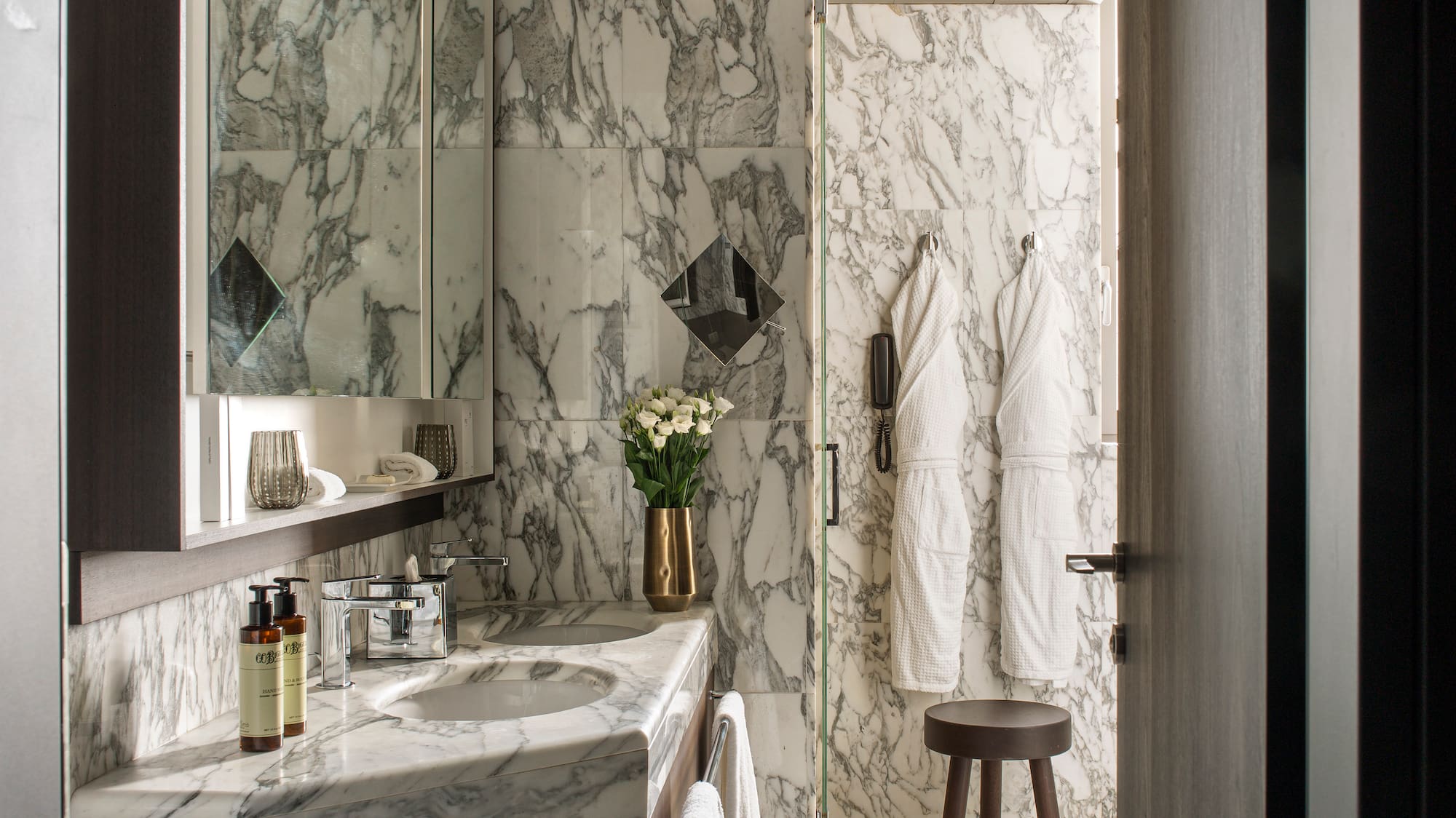 a bathroom with marble walls and a mirror