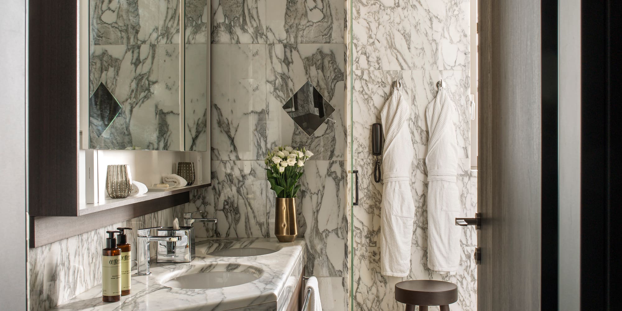 a bathroom with marble walls and a mirror