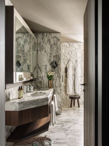 a bathroom with marble walls and a mirror