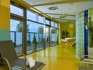 a yellow floor with a chair and a glass wall