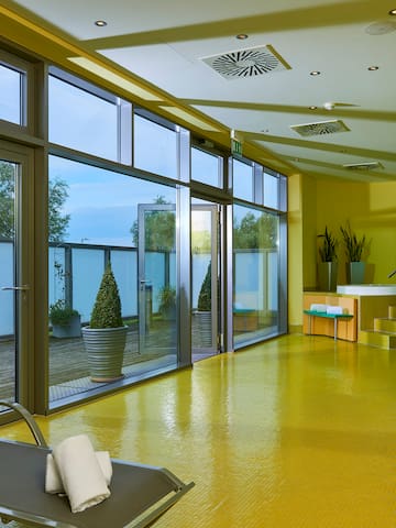 a yellow floor with a chair and a glass wall