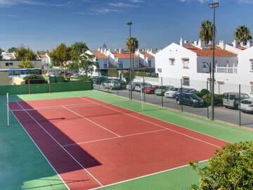 a tennis court with cars parked in front of it