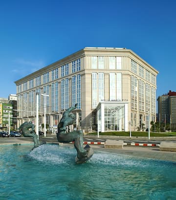 a statue in a fountain in front of a building
