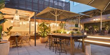 a patio with tables and chairs and umbrellas