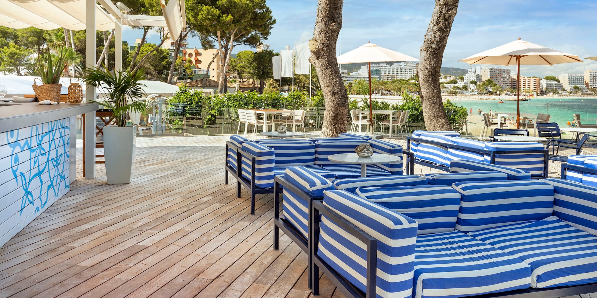 a patio with blue and white striped chairs and tables