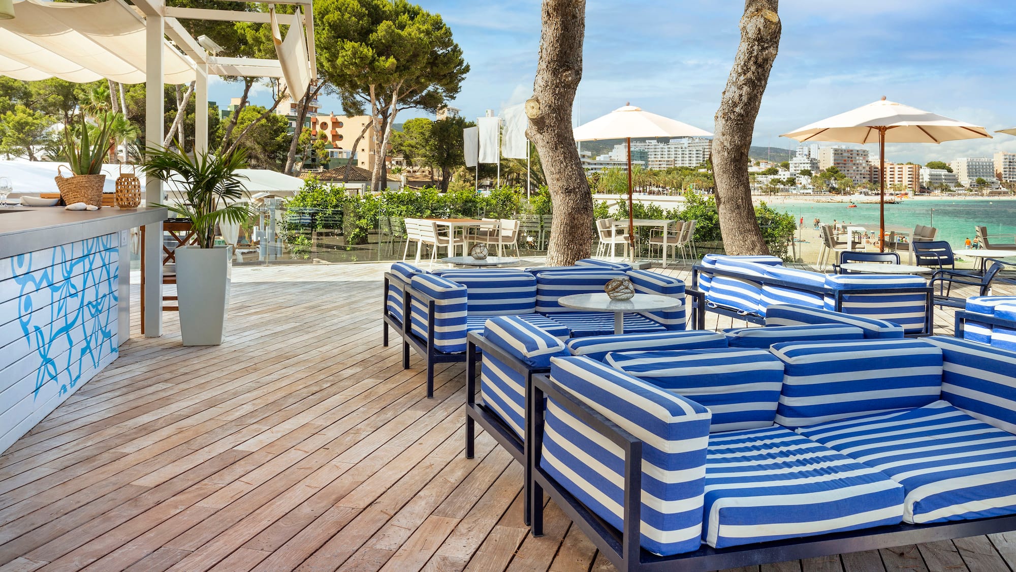 a patio with blue and white striped chairs and tables