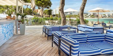 a patio with blue and white striped chairs and tables