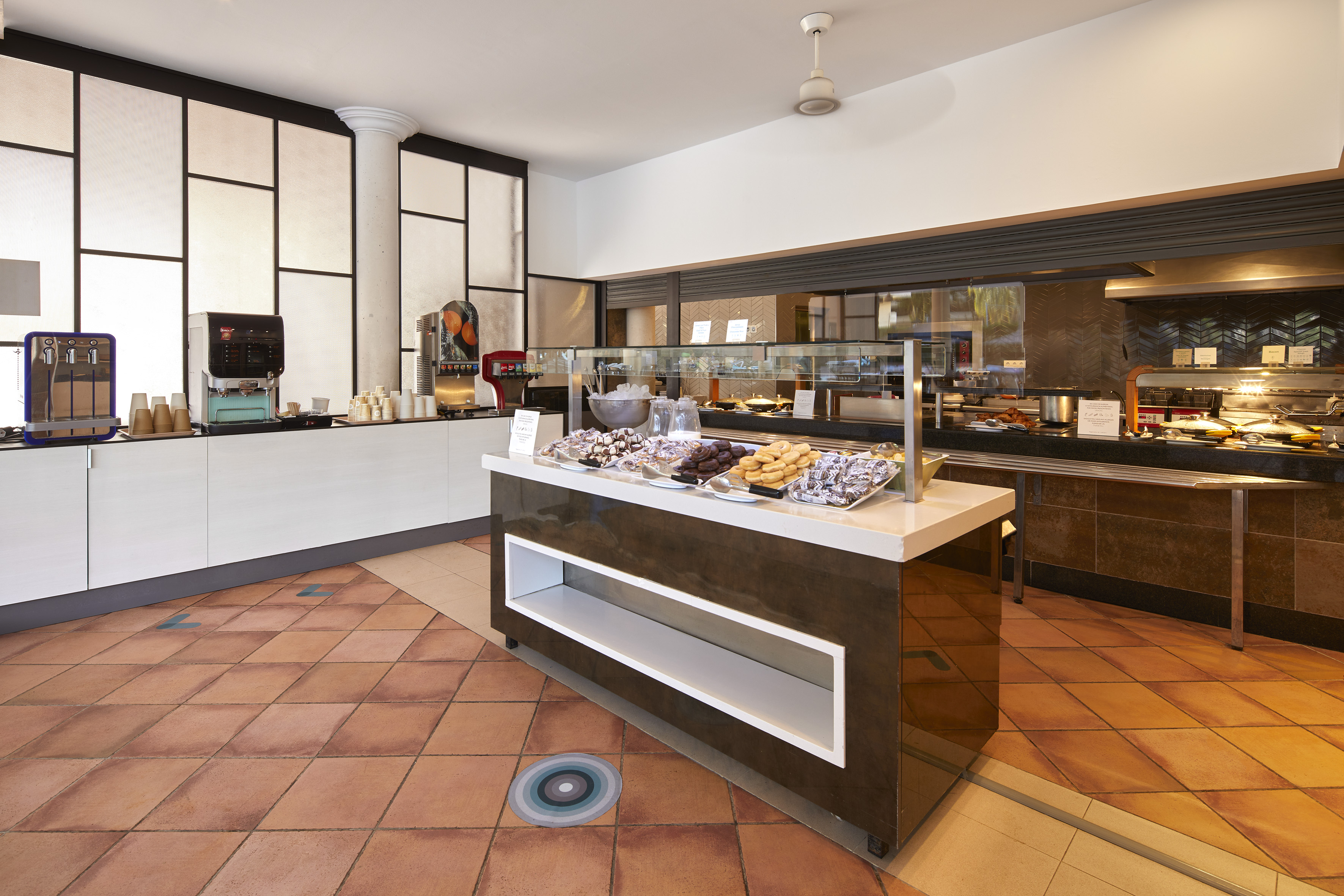 Modern hotel buffet featuring pastries, coffee, and hot breakfast items.