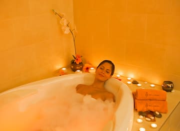 a woman lying in a bubble bath