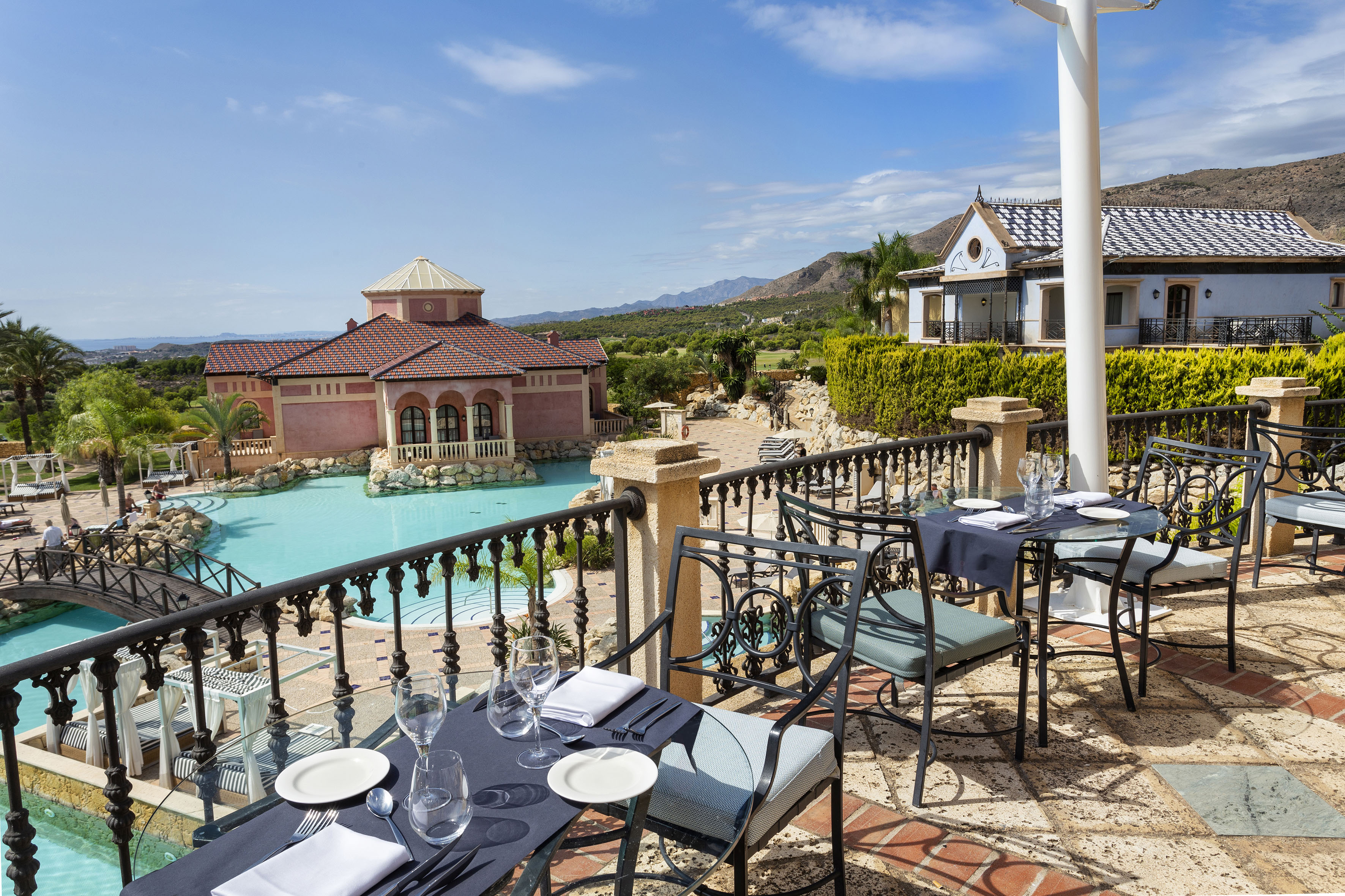 Luxury resort patio dining with swimming pool and mountain views.