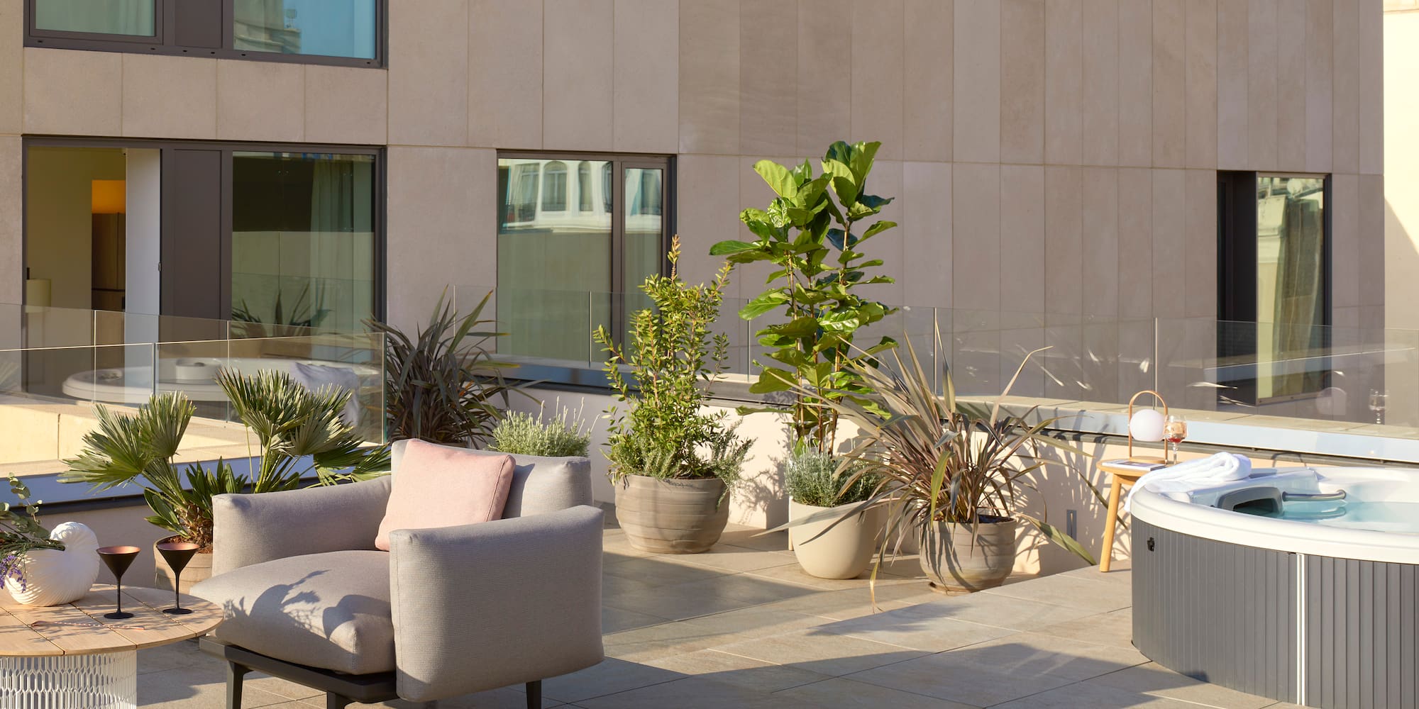 a patio with a chair and potted plants