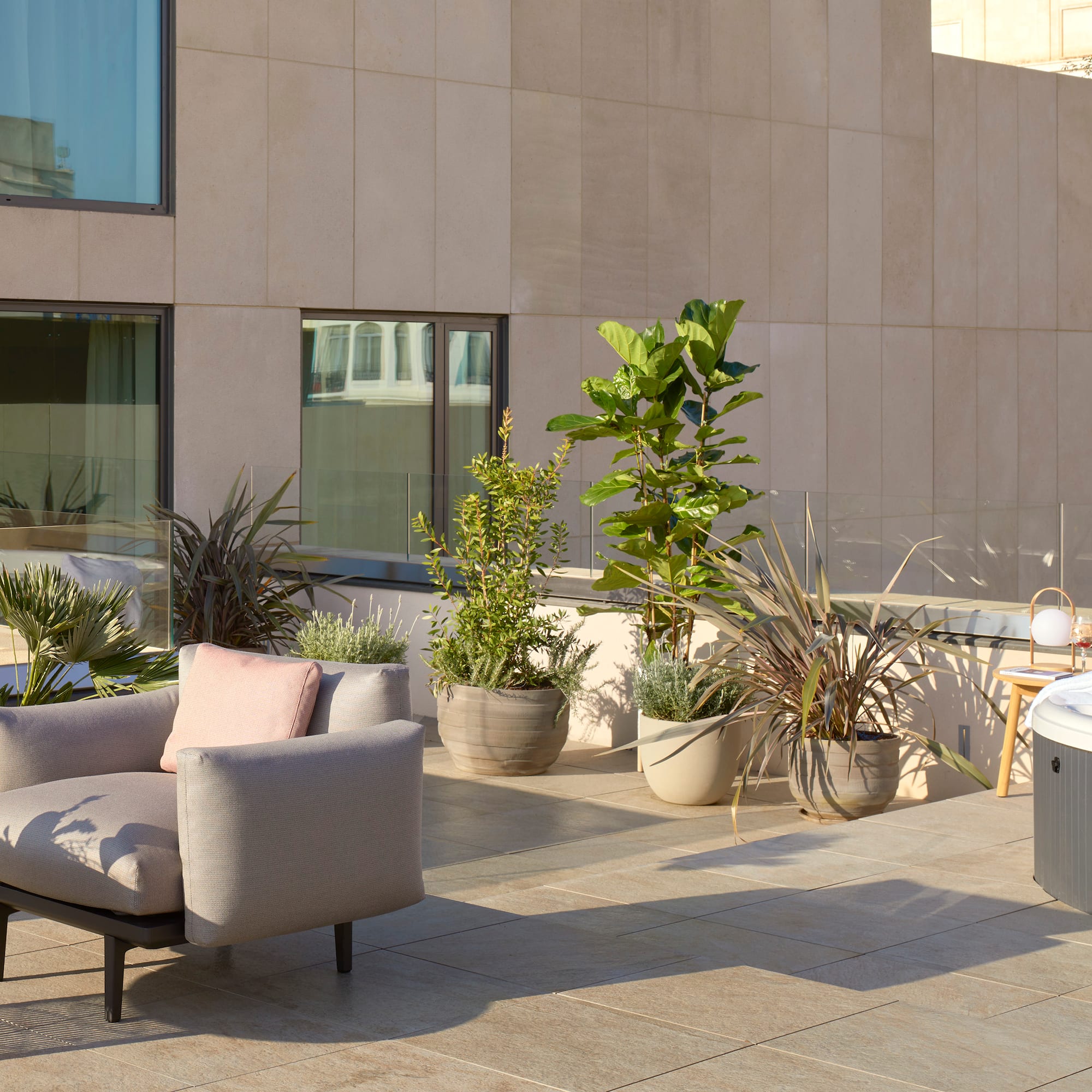 a patio with a chair and potted plants
