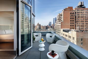 a balcony with chairs and a table and a glass door