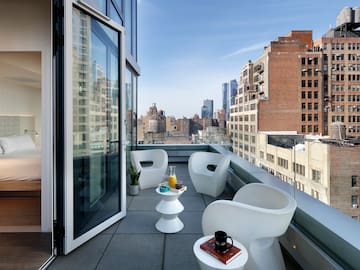 a balcony with chairs and a table and a glass door