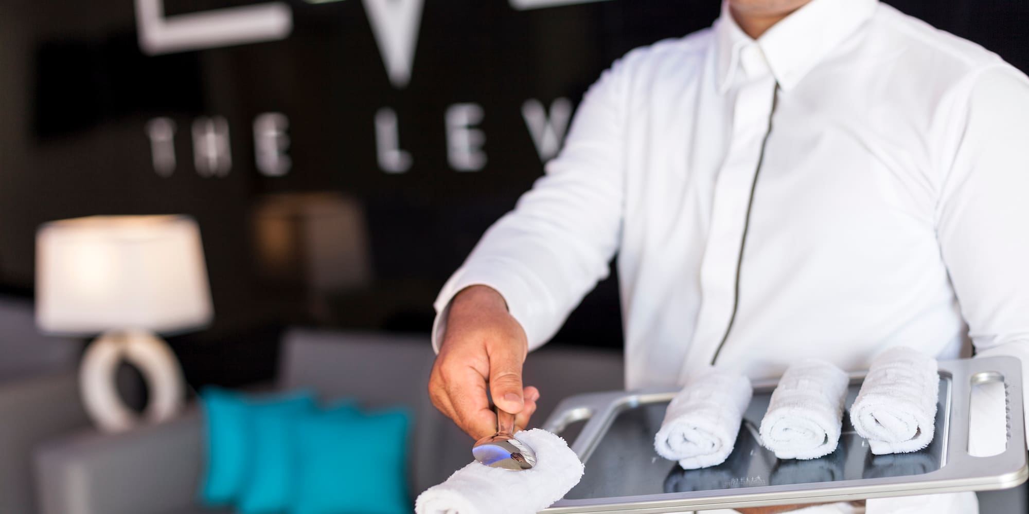a man holding a tray with towels
