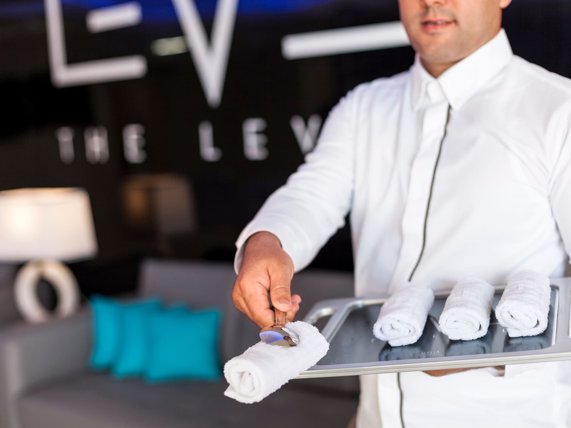 a man holding a tray with towels