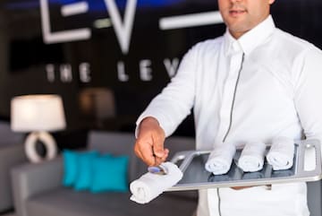 a man holding a tray with towels