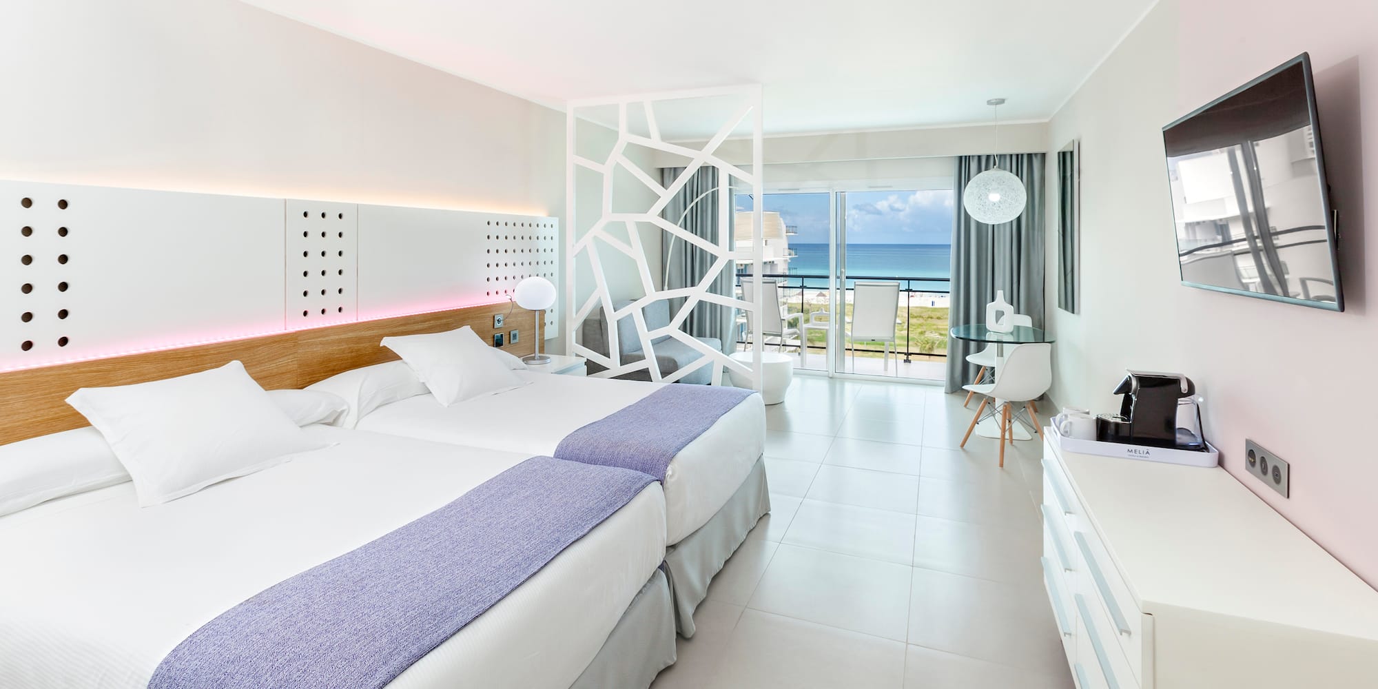 a room with two beds and a glass door