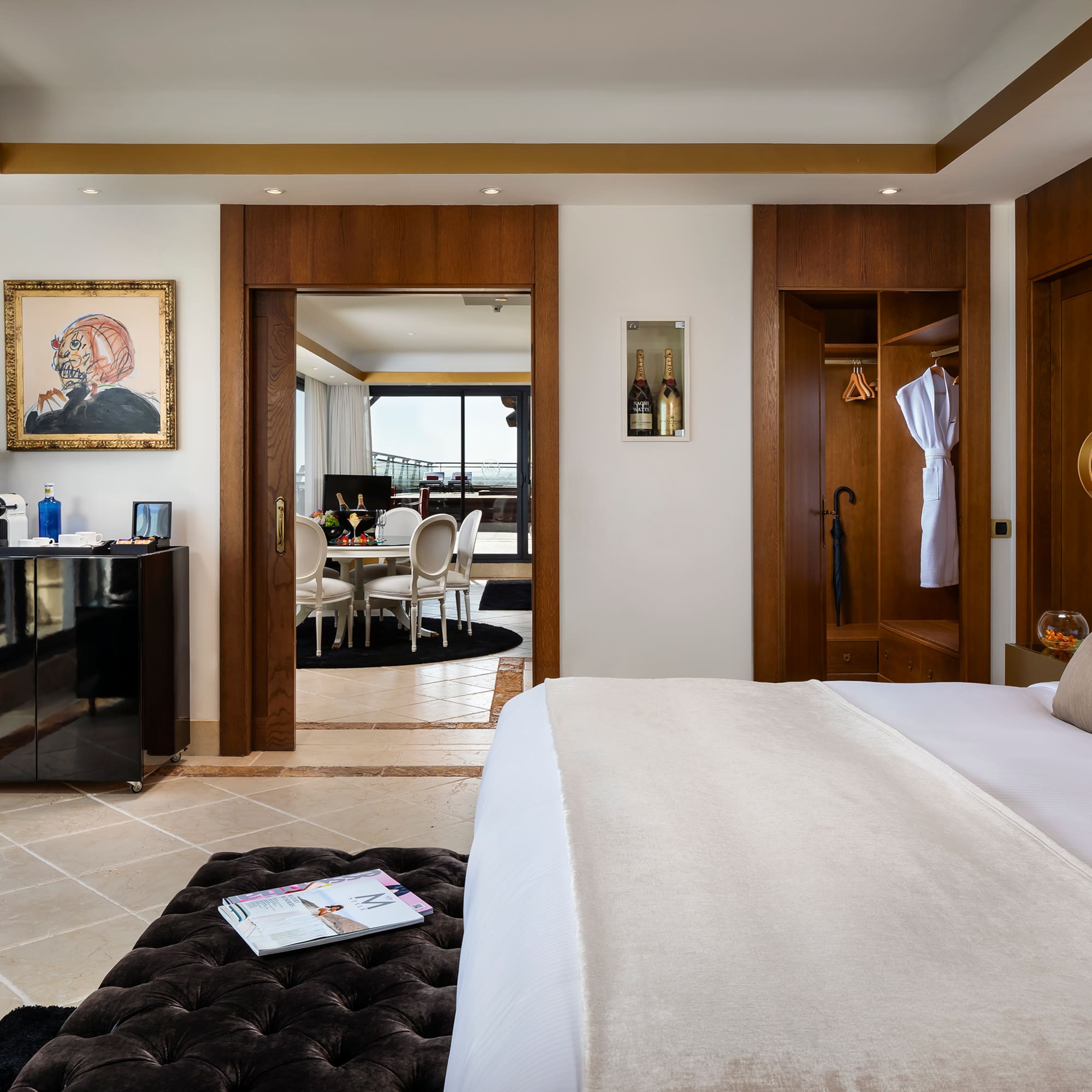 a bedroom with a large bed and a black ottoman