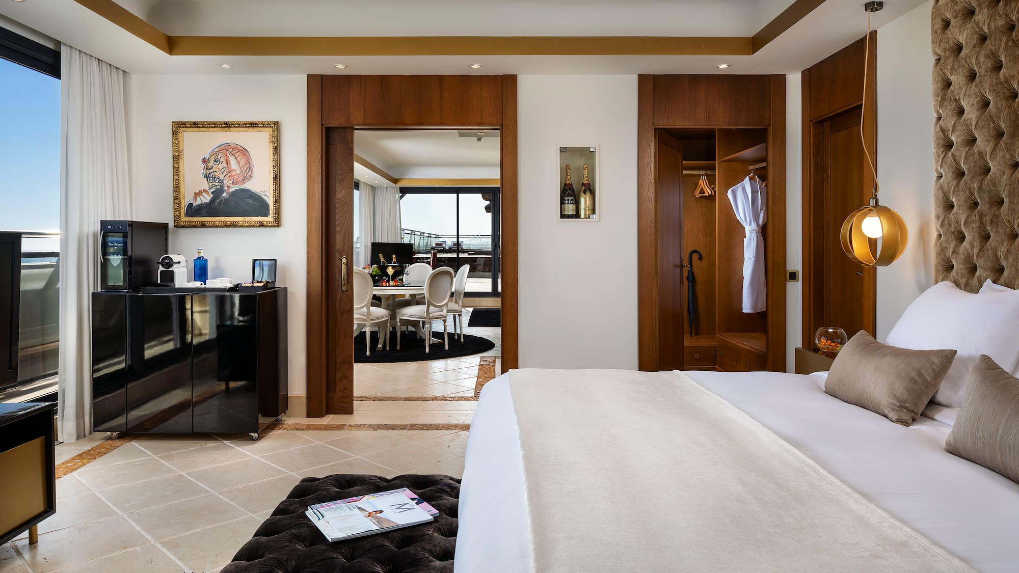 a bedroom with a large bed and a black ottoman