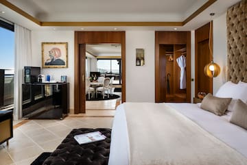 a bedroom with a large bed and a black ottoman