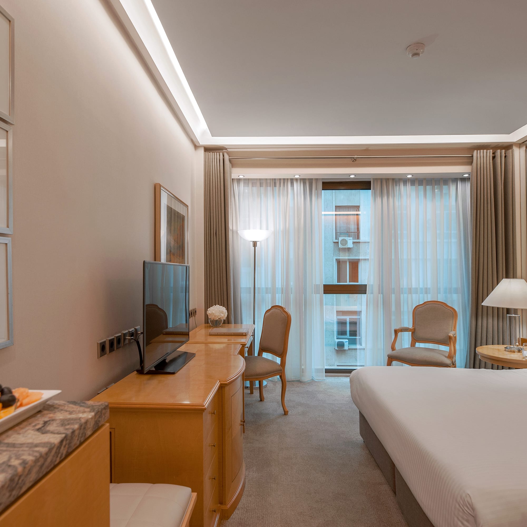 a room with a bed and a table and chairs